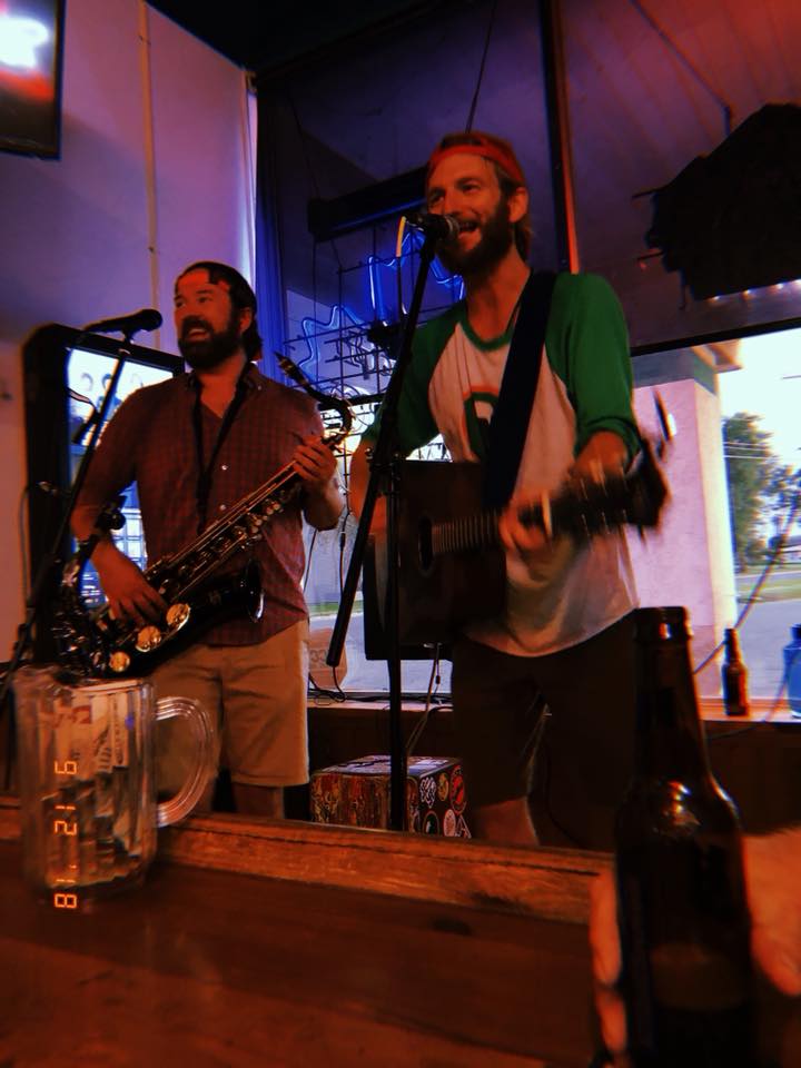 Kristofer singing beside Robbie on saxophone