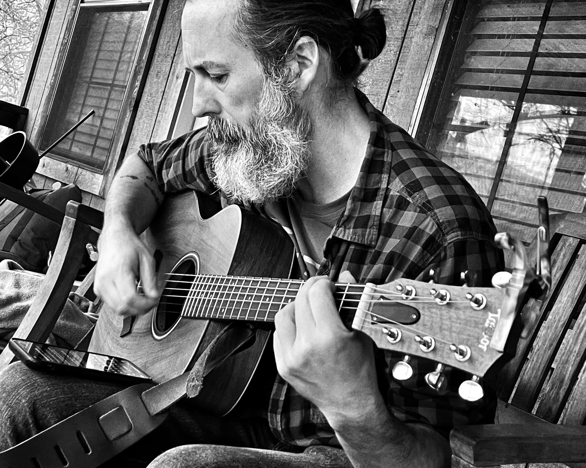 Songwriter with acoustic guitar, black and white